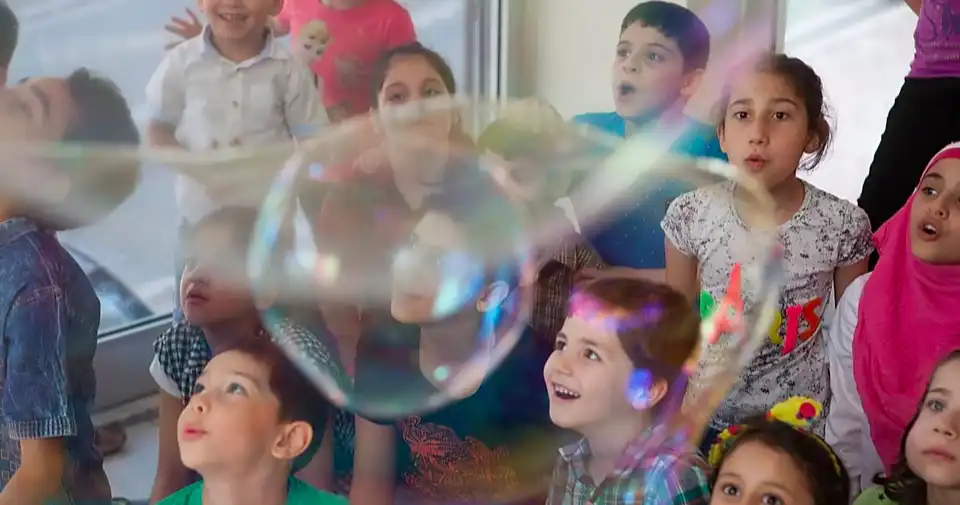 children smiling as bubbles float up